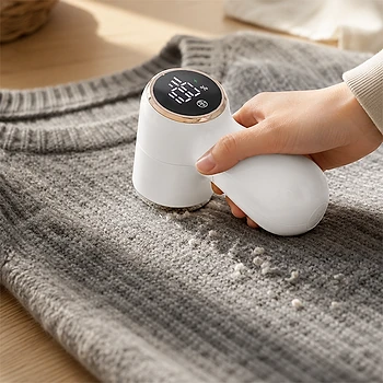 NoFuzz entfernt Fusseln von einem grauen Strickpullover